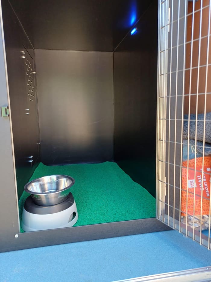 Close-up of an individual travel crate with bedding and water bowl